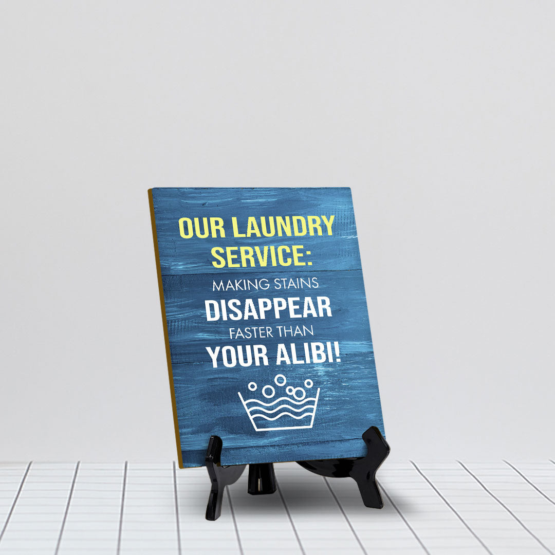 Signs ByLITA Our laundry service: Making stains disappear faster than your alibi! Table Sign with Acrylic Stand (6x8“)